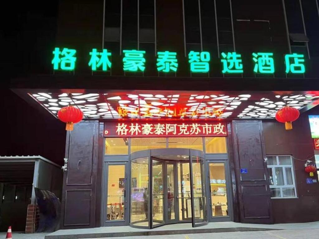 阿克苏市Green Tree Inn Aksu Municipal Government的商店前方有 ⁇ 虹灯标志