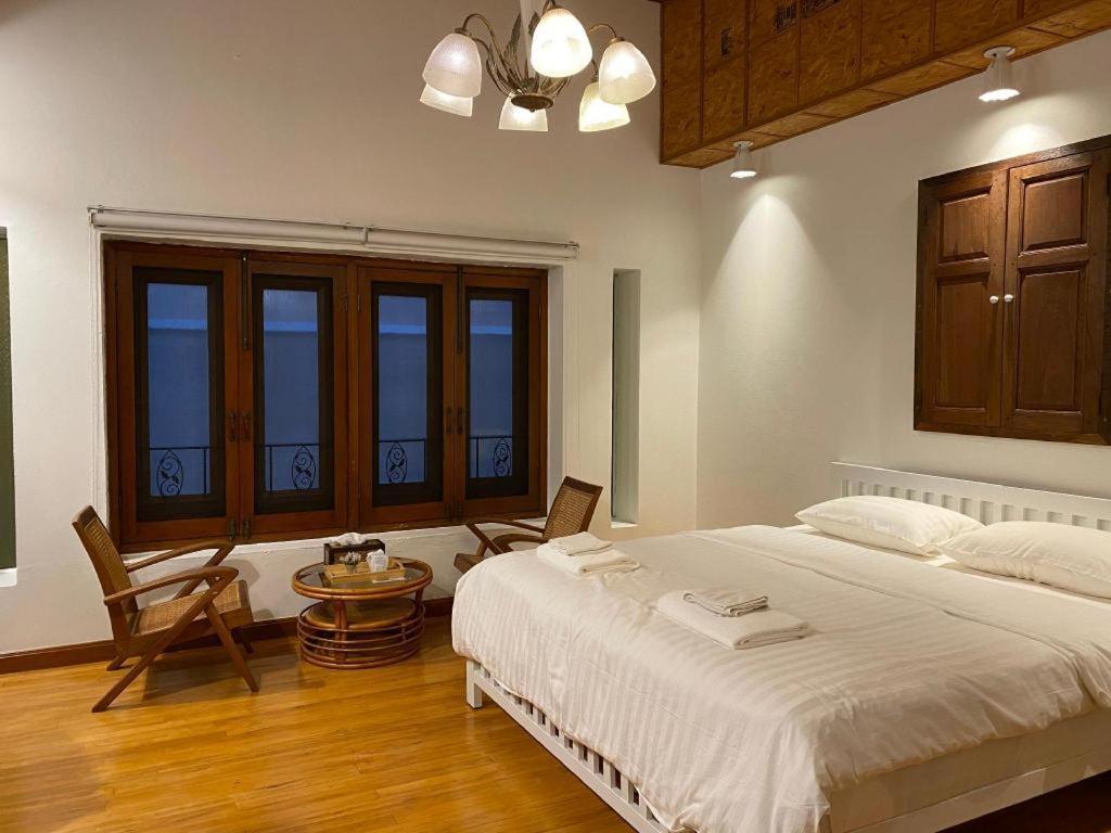 Ban Wa KachieoMe Design khao yai的一间卧室配有一张大床和一张桌子及椅子