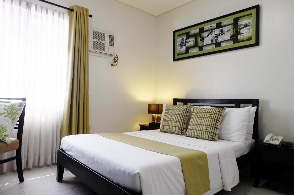 达沃市Hari Royale Suites的一间卧室配有一张大床和一部电话