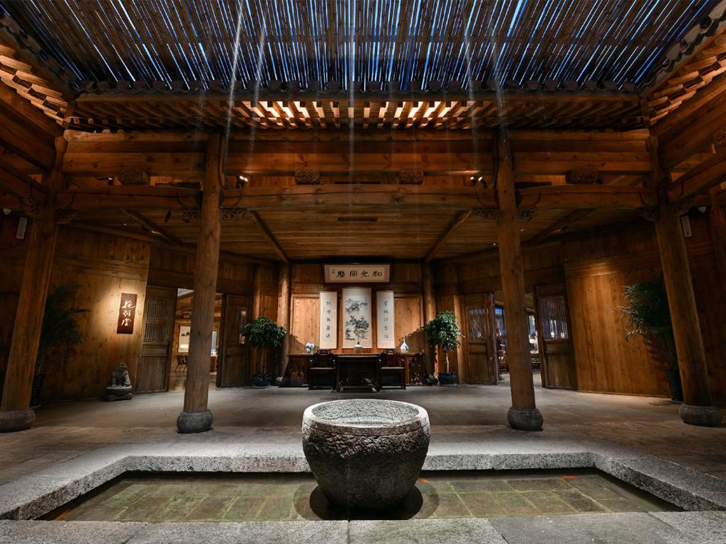 济南Blossom House Jinan Shunlu的一间大房间,在建筑中间有一个石头碗