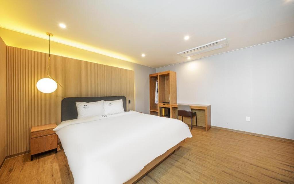 庆州H Avenue Gyeongju的卧室配有一张白色大床和一张书桌
