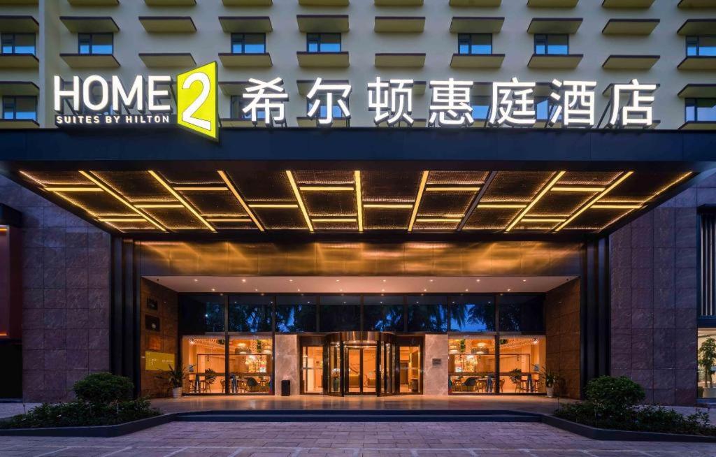 景洪市Home2 Suites by Hilton Xishuangbanna的带有读回家的标志的建筑,开始我的厨房