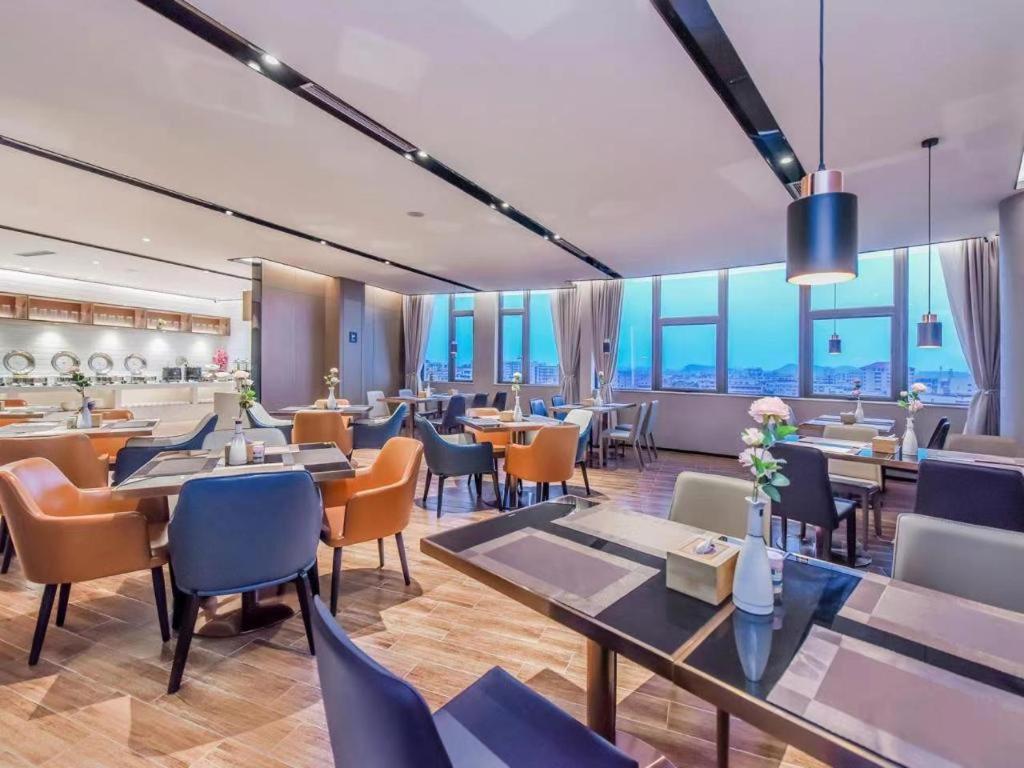 贵阳Echarm Hotel Guiyang Zhongshan West Road Metro Station的餐厅设有桌椅和窗户。