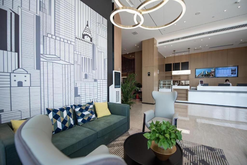 QuelingzuiCity Comfort Inn Ezhou Wuyue Plaza的带沙发的客厅和厨房