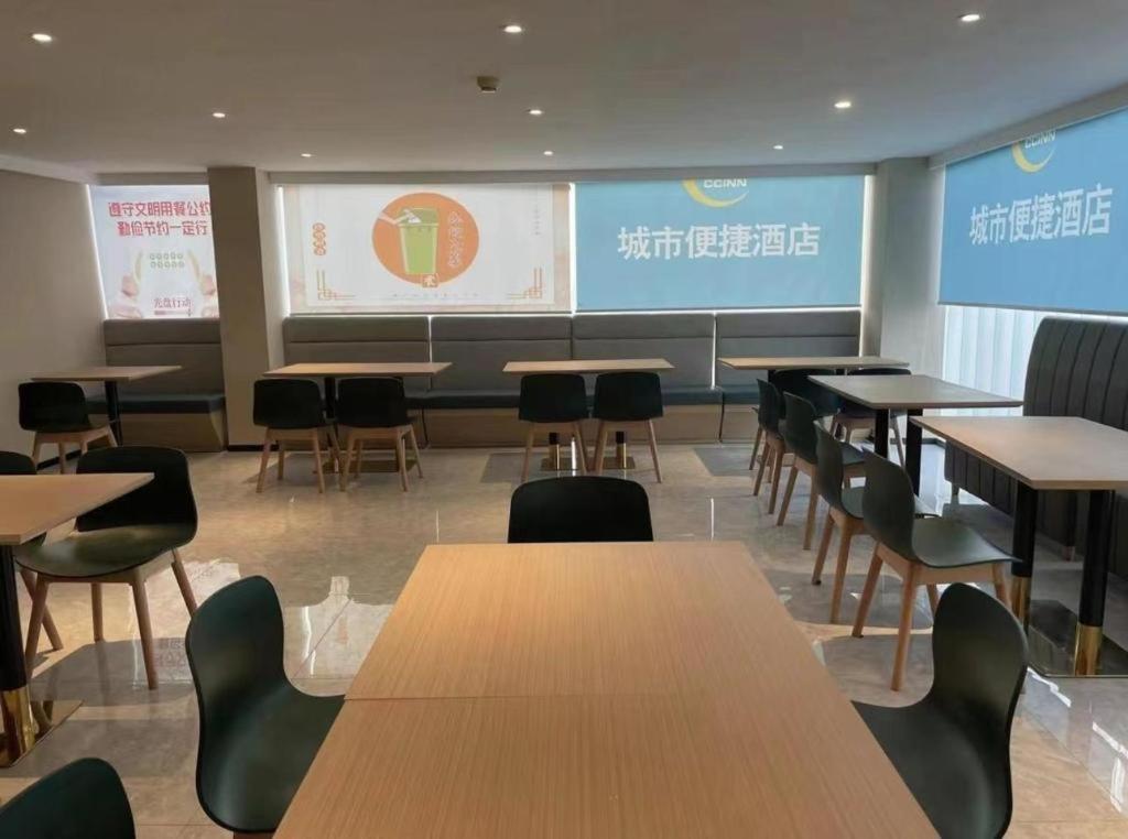 TaheCity Comfort Inn Beijing Capital Airport Shunyi Metro Station的配有桌椅和投影屏幕的教室