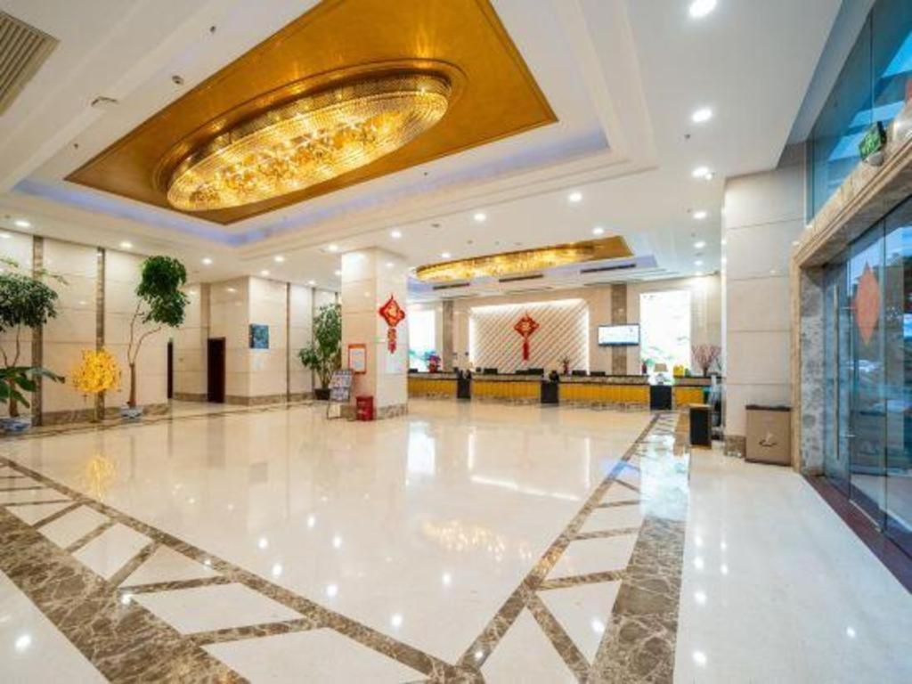HeshanBashan Hotel的大堂设有大型白色地板和金色天花板