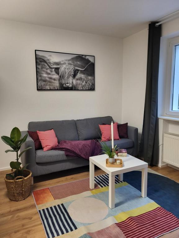 新乌尔姆ALA Living Stadt-Schwärmer Apartment 10min zum Ulmer Münster & Ulmer Altstadt, WLAN & Arbeitsplatz的客厅配有沙发和桌子