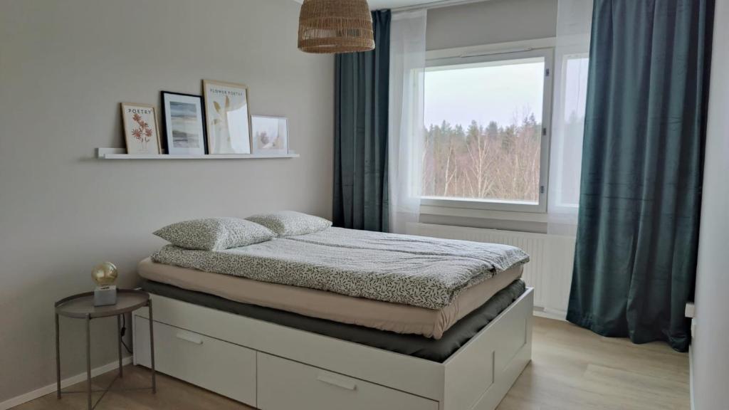 万塔Green Getaway - near Helsinki Vantaa Airport, top-floor, free parking & wifi的窗户客房内的一张床位