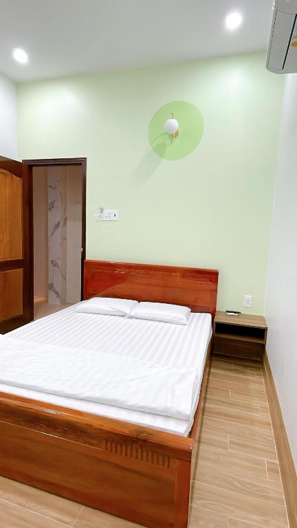 Xóm Tràm CửaNhà Nghỉ Thảo Tiên的一间卧室配有一张带白色床单的大床