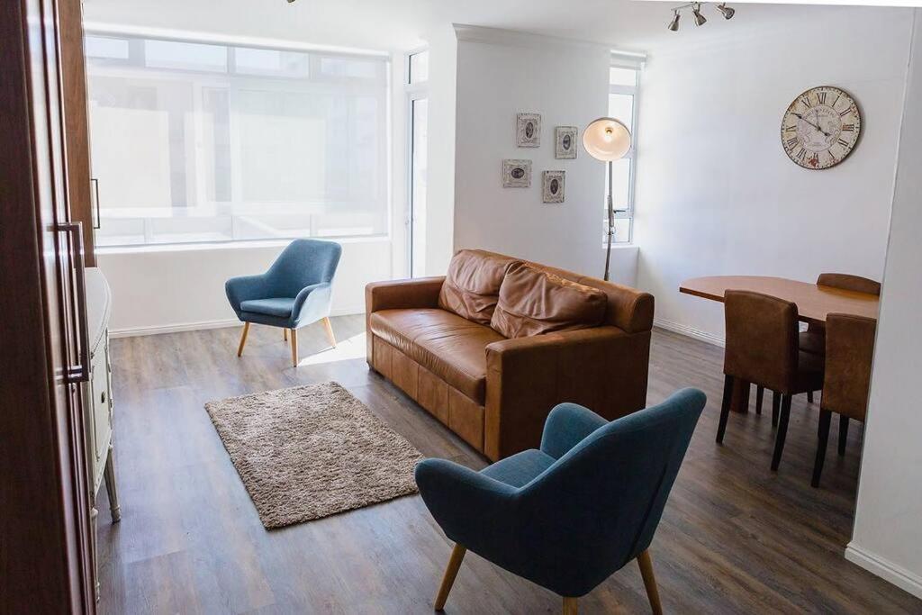 开普敦Modern apartment, centrally located in Sea Point的客厅配有沙发、椅子和桌子
