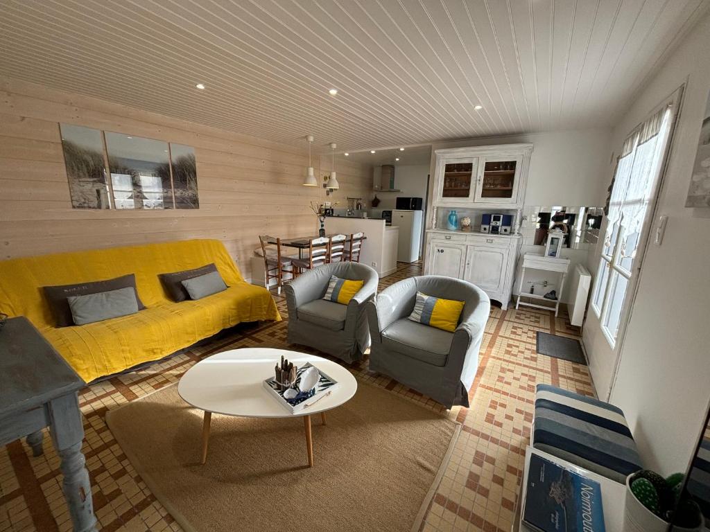 诺亚芒提亚Maison Bord de Mer au Vieil 3 étoiles的客厅配有黄色的沙发和桌子