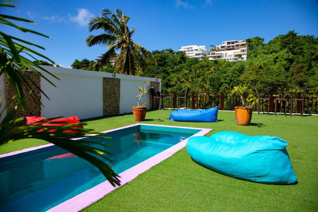 长滩岛Chillax Boracay的后院设有游泳池和绿草