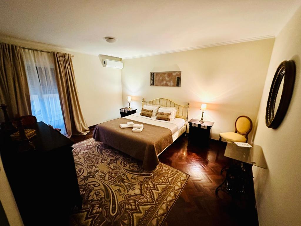 蓬塔德尔加达DMCharme的配有一张床和一把椅子的酒店客房