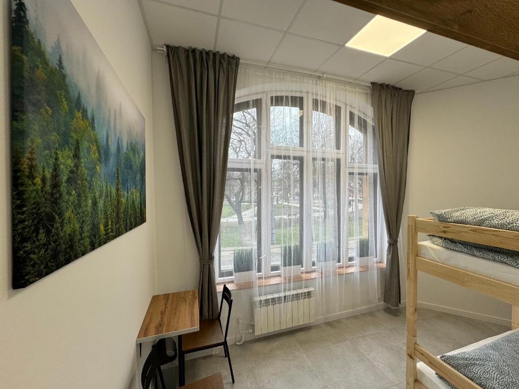 卡托维兹Green Hostel Katowice - 24h Free Parking的卧室设有窗户,墙上挂有绘画作品