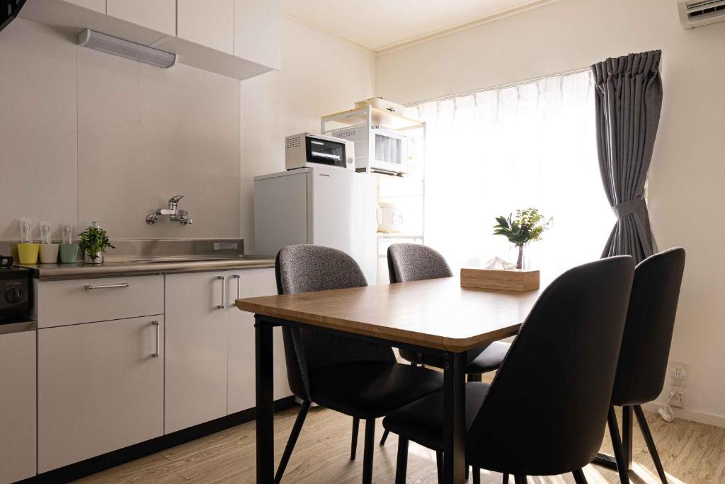 冈山Lino下伊福的厨房配有木桌和黑色椅子