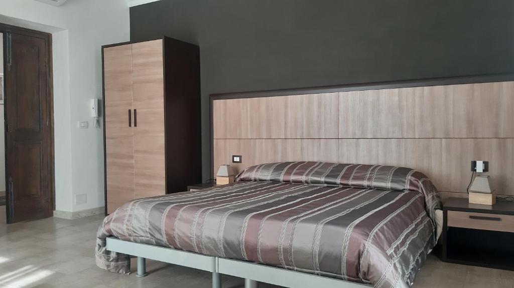 锡拉库扎Casa Antioco B&B的一间卧室设有一张大床和一个大型床头板