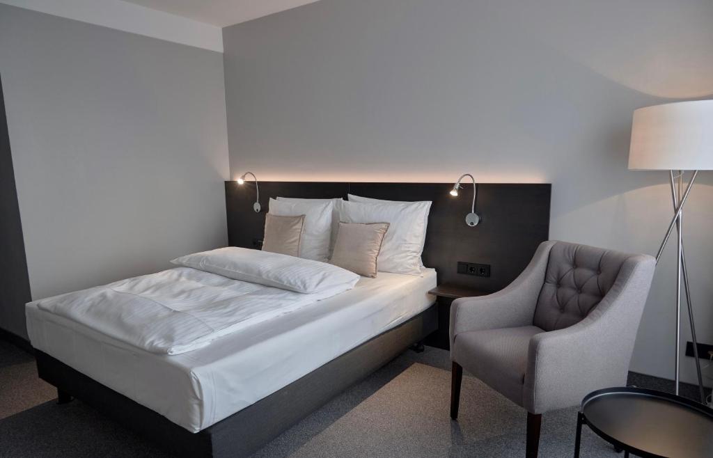 明登明登林佳特酒店 的一间卧室配有一张床和一把椅子