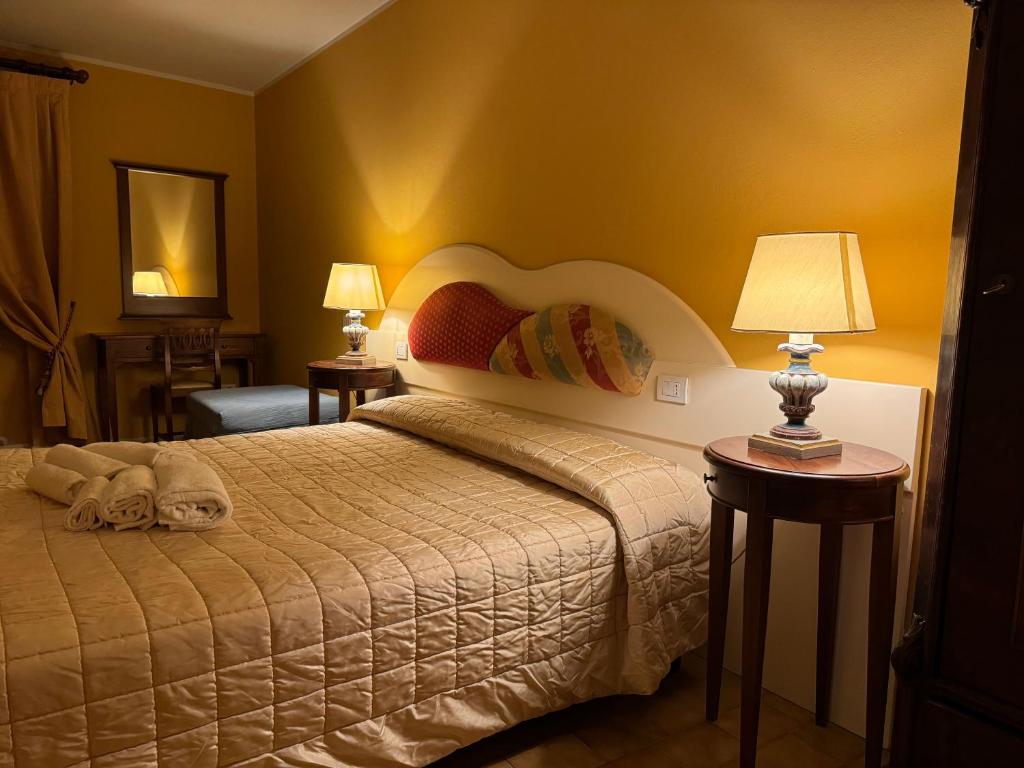 巴尼奥迪罗马涅Albergo Roma的一间卧室配有一张床和两张带台灯的桌子。
