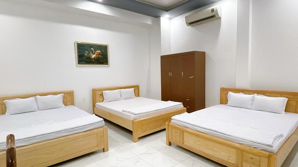Vị ThanhNhà Nghỉ Hạnh Phúc的一间设有两张床和橱柜的房间