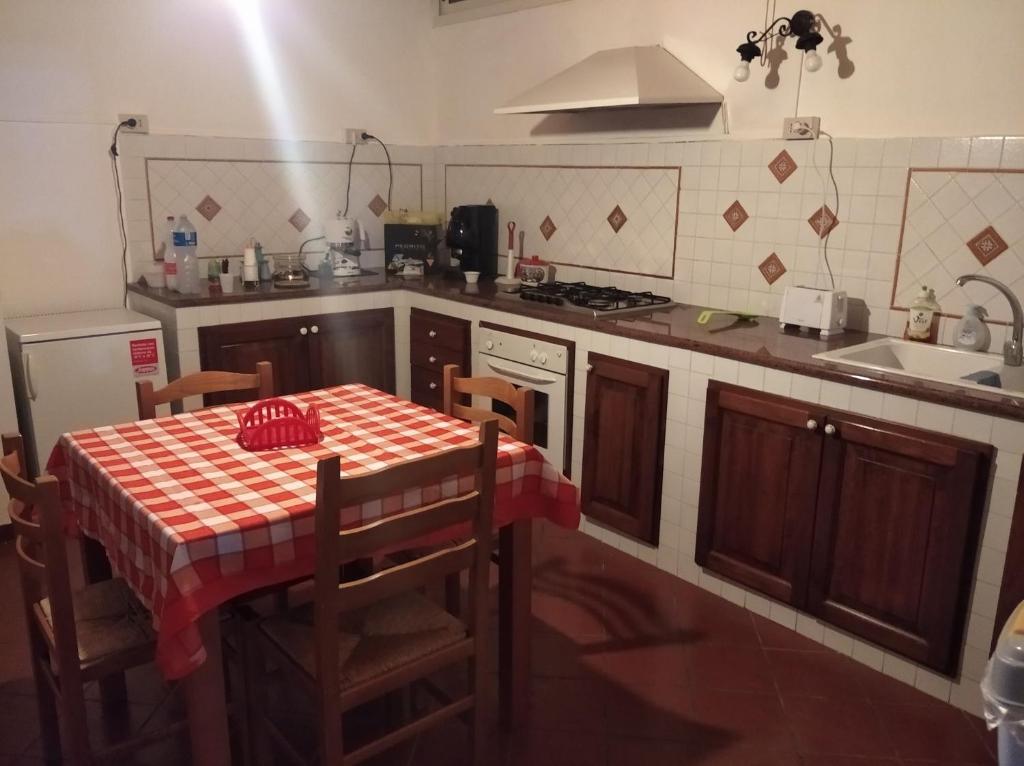 奇尼斯B&B vacanze Mille Colori的厨房配有一张桌子和红色的桌布