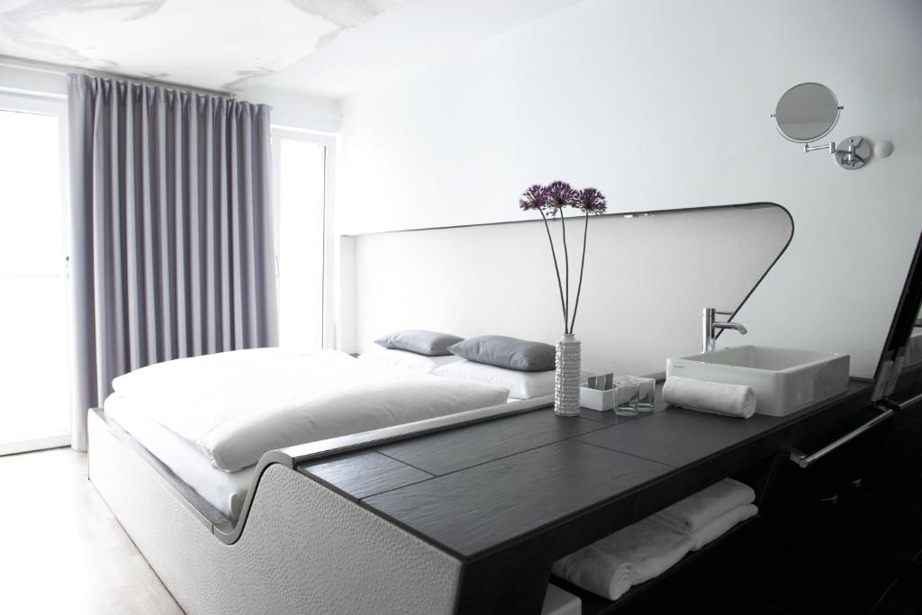 柏林柏灵Q!酒店的白色卧室配有一张大床和一张桌子