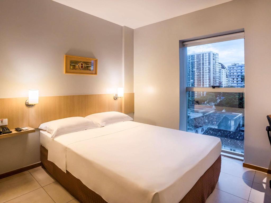 贝伦ibis Styles Belém do Pará的一间卧室设有一张大床和一个窗户。