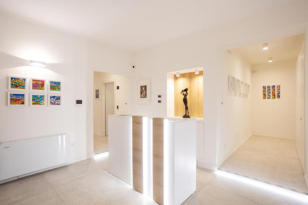 莱切Lo Studio di viale Lo Re camere & caffe’的一间拥有白色墙壁和壁画的房间