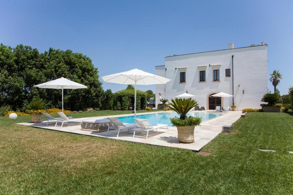 加拉蒂纳Villa Maxima Privacy and Pool - Happy Rentals的一座带椅子和遮阳伞的游泳池位于一座建筑旁边
