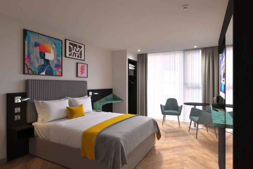 曼彻斯特Maldron Hotel Manchester Cathedral Quarter的酒店客房带一张床、一张桌子和椅子