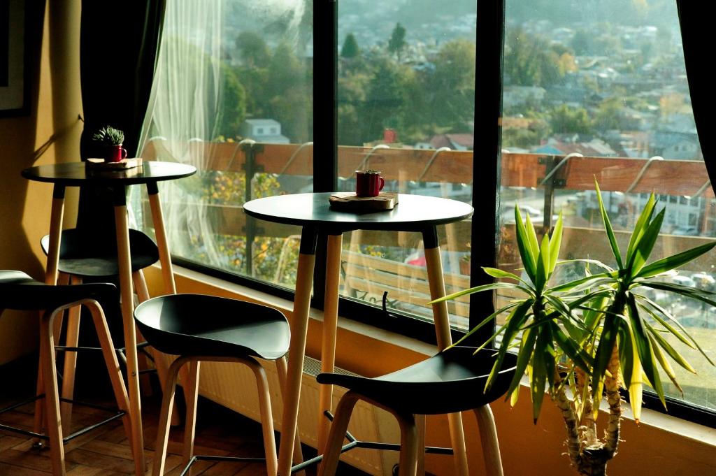 蒙特港塞米纳里奥酒店的两把桌子和椅子位于大窗户前