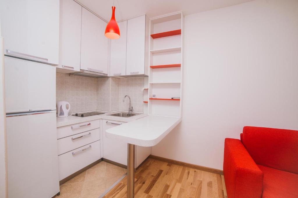 蒂瓦特Apartment DV Magnolia的厨房配有水槽和红色椅子
