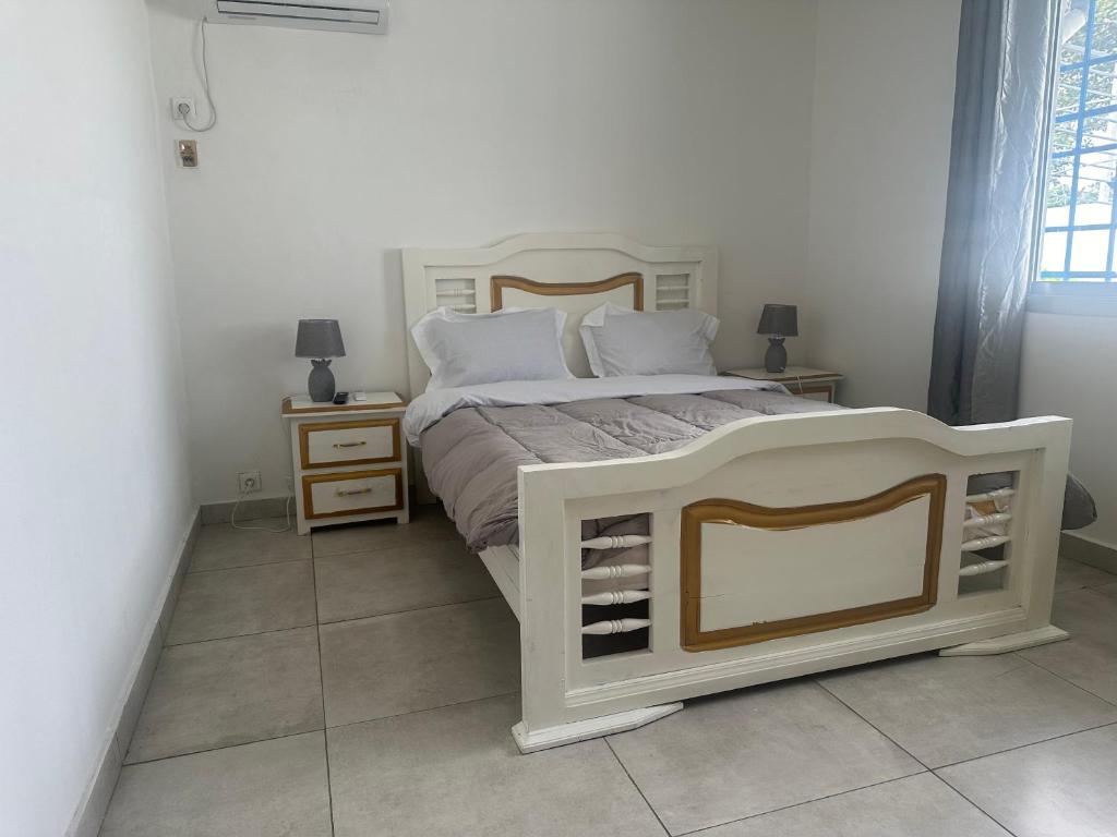 利伯维尔Villa bord de mer louis的卧室配有白色的床和2个床头柜