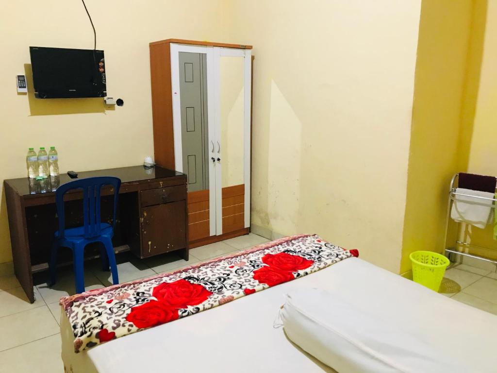 普拉亚Wisma Dhana Syariah的一间卧室配有一张床、一张书桌和一面镜子