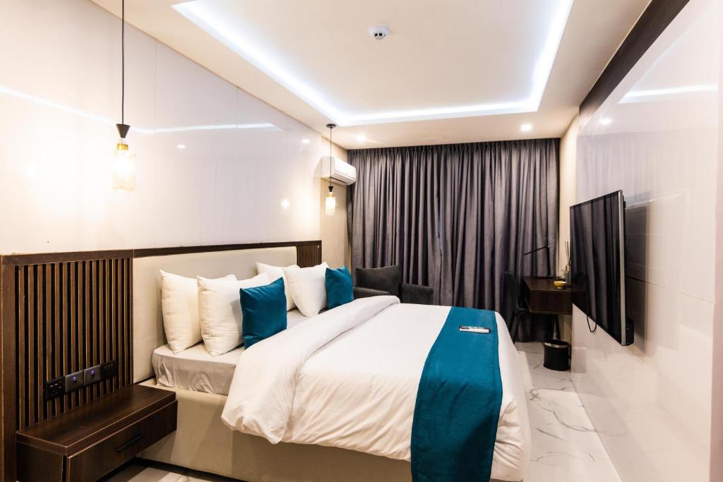 阿布贾BON Hotel Nest Garki II Abuja的一间卧室配有一张带蓝色枕头的大床