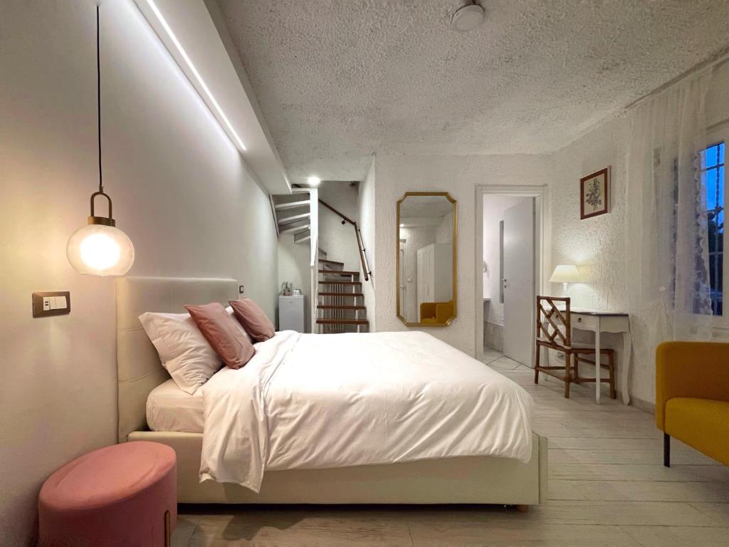西尔米奥奈Villa Pensione Mercedes的卧室配有白色的床和粉红色凳子