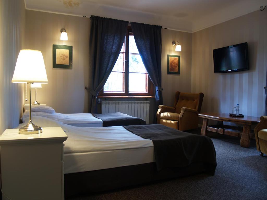 维什库夫Leśny Dworek的酒店客房设有两张床和电视。