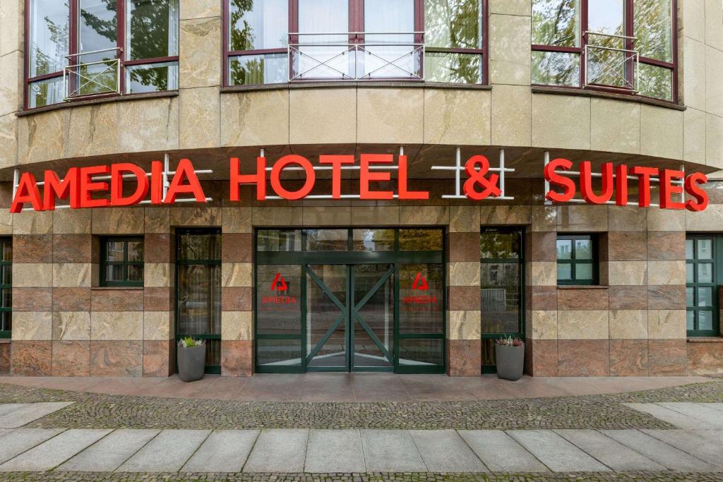 莱比锡Amedia Hotel &amp; Suites Leipzig, Trademark Collection by Wyndham的酒店建筑侧面有招牌