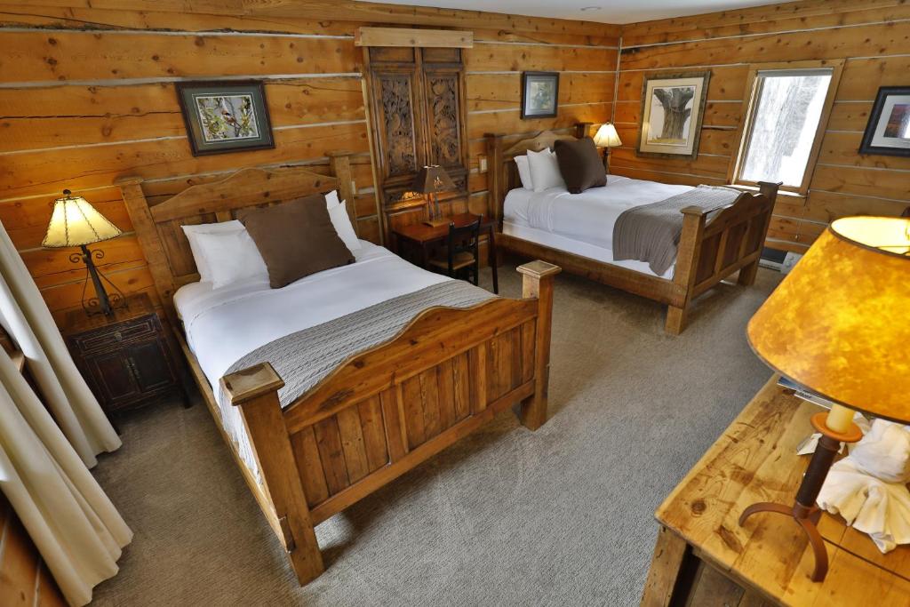 威尔森曲木客栈的小木屋内一间卧室,配有两张床