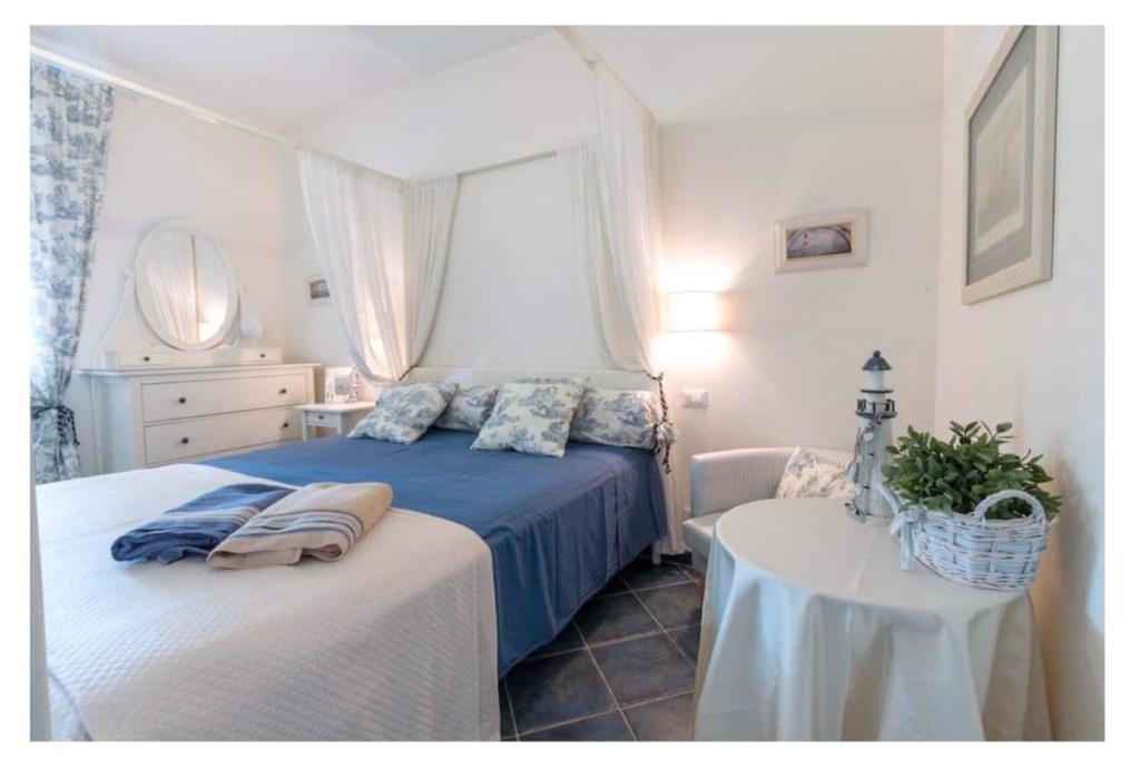 圣卡特琳娜迪纳德Residence Le Cenate的一间卧室配有一张蓝色的床和一张桌子