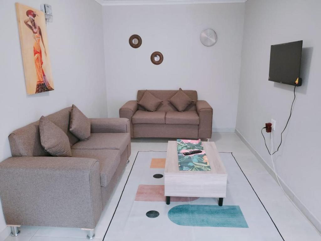 塞昆达Reutlwane Gardens Apartments的客厅配有两张沙发和一张咖啡桌