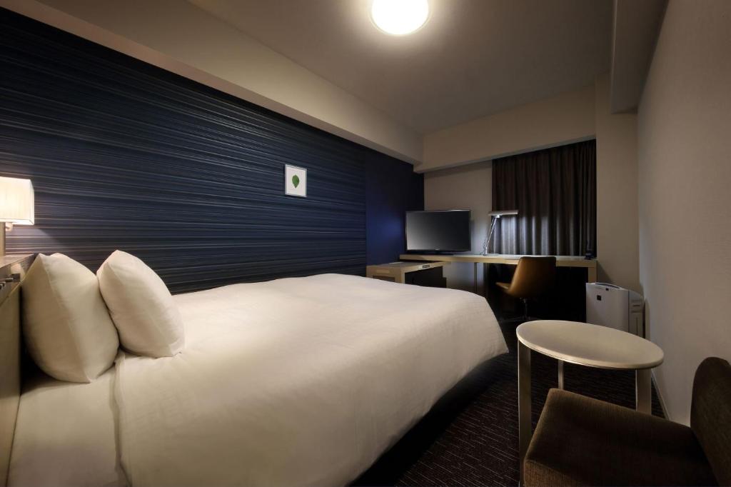 福岛福岛站前里士满酒店的酒店客房设有一张白色大床和椅子