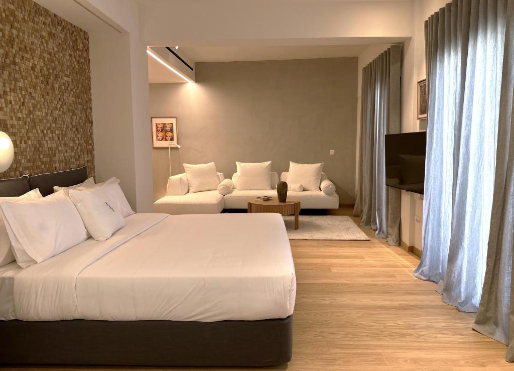 雅典AIONION RESIDENCES by K&K的卧室配有一张白色的大床和一张沙发。