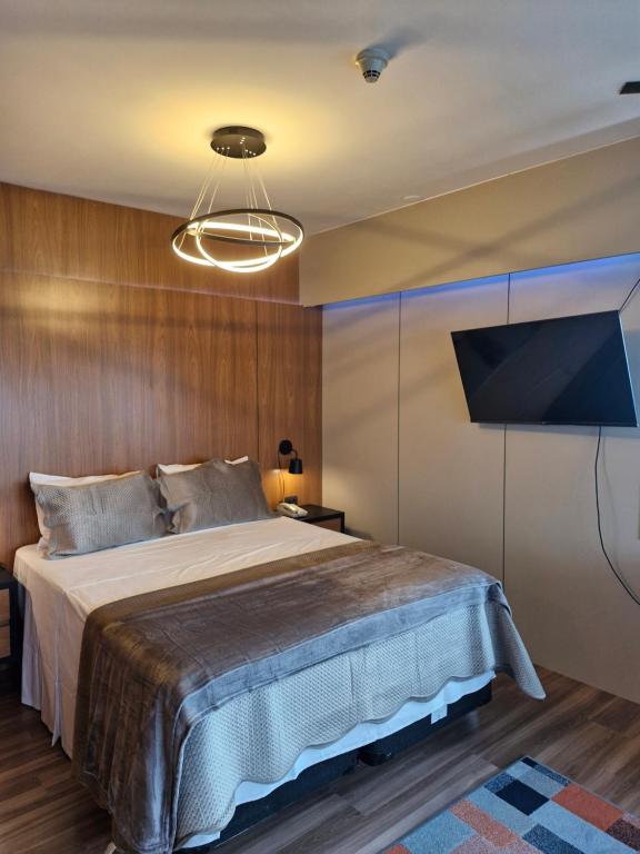 圣保罗Hotel Blue Boutique Paulista的一间带大床和电视的卧室