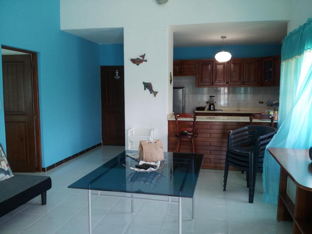 博卡奇卡Apartment Caribbean Relax的厨房前设有带玻璃桌的客厅