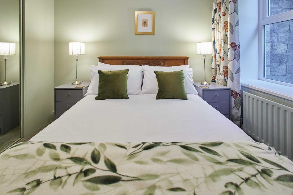 GreetlandHost & Stay - Ormesby的卧室内的一张大床,配有两盏灯