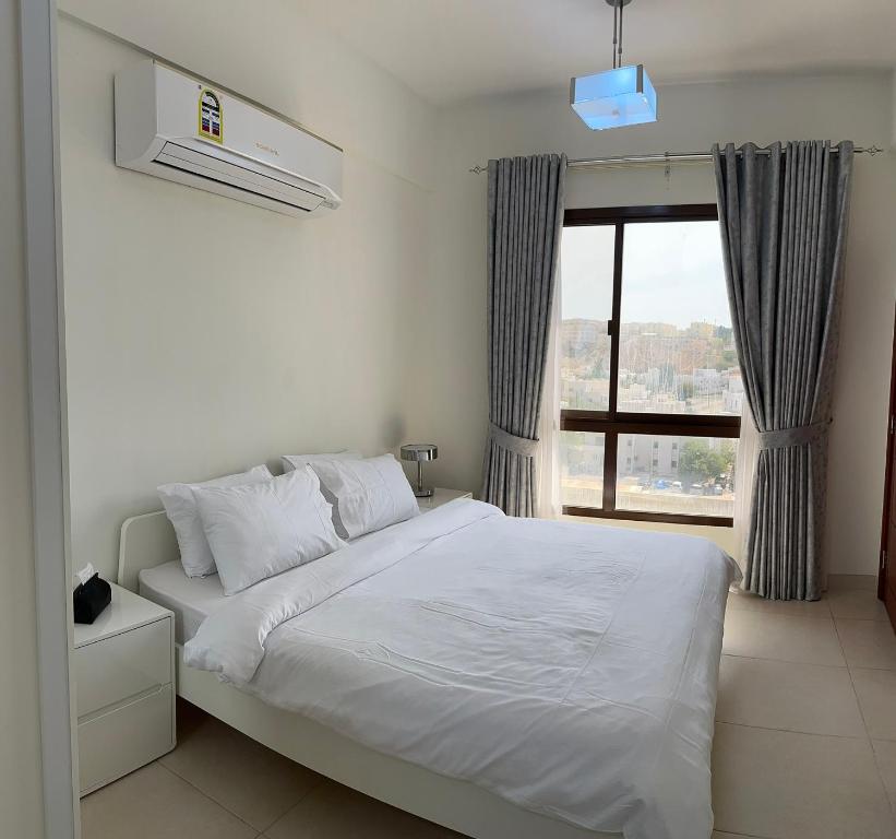 马斯喀特City Gem BAQ的卧室配有白色的床和窗户。