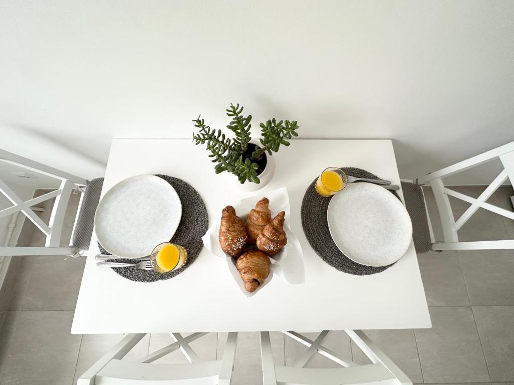 希卢泰Jaukūs apartamentai Šilutėje的一张白色桌子,上面放着鸡蛋和羊角面包