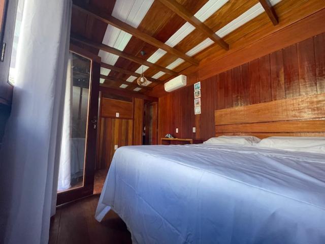 伊塔帕里卡岛维拉克鲁兹Chalés Mãe Natureza的卧室配有白色的床和木墙