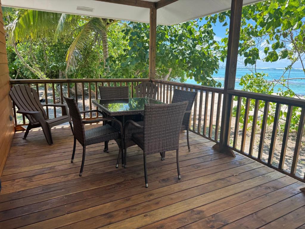 PareaParea Lodge Huahine Bungalow 1#MAHANA的甲板上配有桌椅的门廊