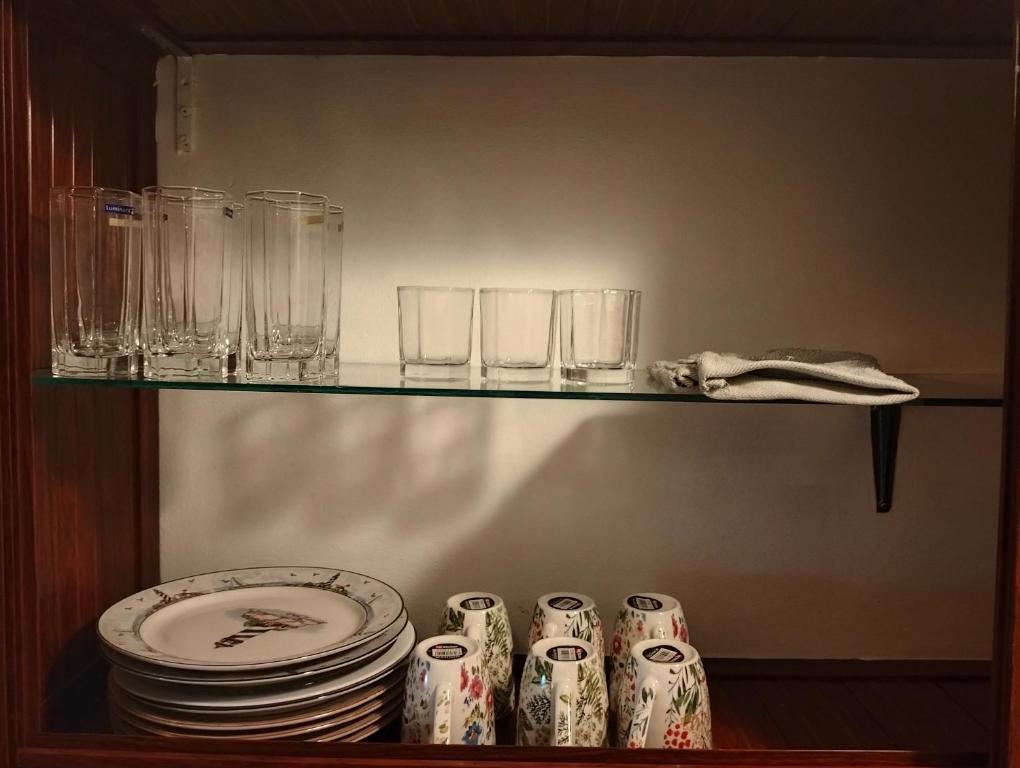 格兰贝伊Grand Baie Holiday Apartment的架子上装有盘子和玻璃杯